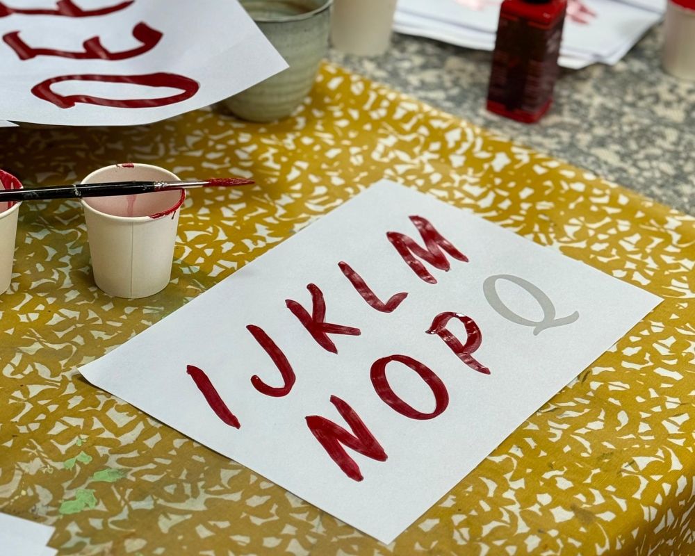 painted letters on a piece of paper in red paint