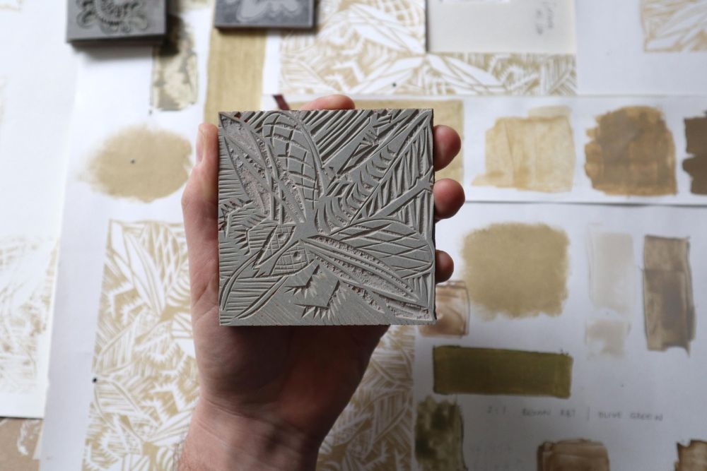 Hand holding a lino carved block print facing the camera