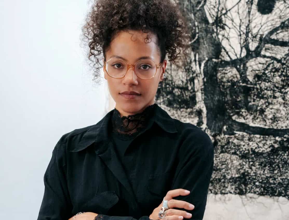 portrait of woman artists in front of black and white textile works